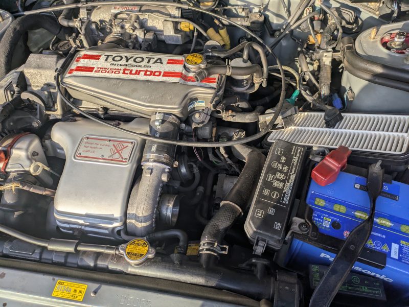 トヨタセリカST165のエンジンルーム。レリーズシリンダーのエア抜きバルブにアクセスするためダクト類を取り外した状態。