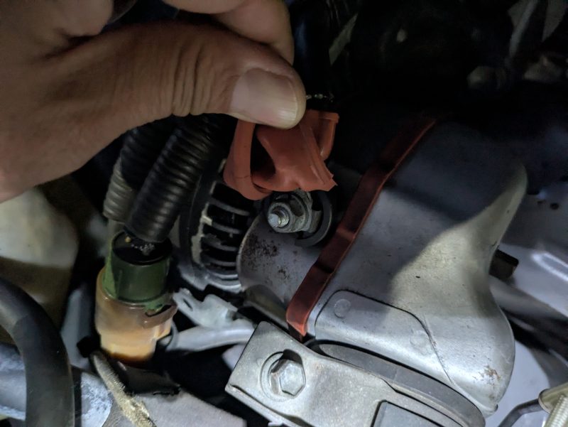 画像4：オルタネーター端子・コネクター部分 ファイル名：st165-alternator-connector-terminal-check.jpg キャプション：オルタネーター本体のナットとコネクターを確認。目視する限り緩みはなし。 代替テキスト：トヨタセリカST165のオルタネーター端子とコネクター部分。接触不良・緩みの確認作業中の様子。 